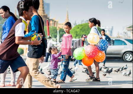 Familien genießen einen Tag mit Tauben, kaufen Spielzeug und Ballons und gehen entlang der Promenade vor dem Königspalast Phnom Penh Cambodi Stockfoto