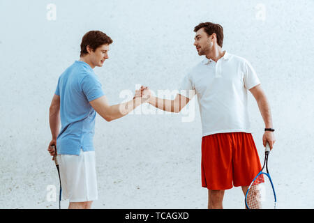 Zwei Squash Spieler mit rackets Hände schütteln und bei jedem anderen Suchen Stockfoto