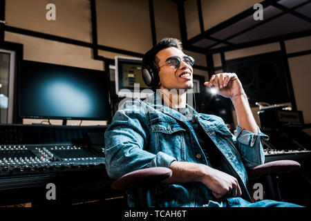 Gut aussehender, gemischten Rennen sound Hersteller in Kopfhörer Musik hören im Recording Studio Stockfoto
