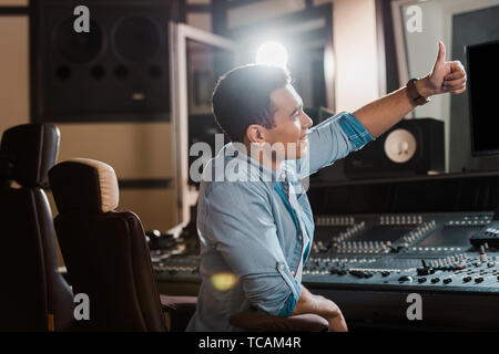 Lächelnd Mixed Race Sound Hersteller zeigen Daumen hoch, während sie im Recording Studio arbeiten Stockfoto
