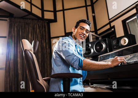 Heiter gemischt Rennen sound Hersteller in Bürostuhl in Recording Studio und Kamera sitzen Stockfoto