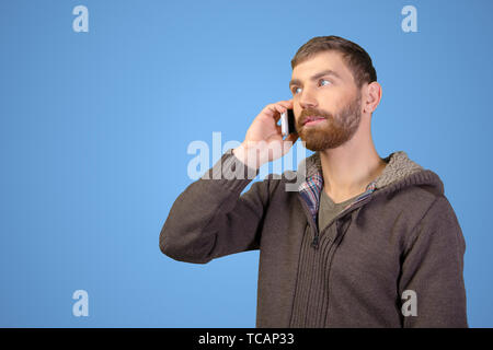 Junger Mann auf dem Smartphone Stockfoto