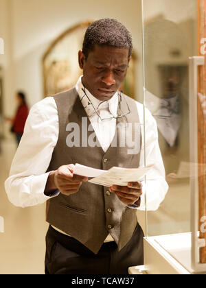 Positive afro-amerikanischer Mann mit Ratgeber stehen in der Halle der Kunst Museum Stockfoto