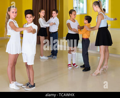 Positive Kinder tanzen Walzer in der Klasse. Stockfoto