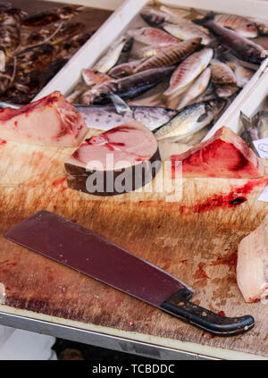 In der Nähe der Fotografie von geschnittenen tote Fische auf einem Holztisch mit Blut und großen Cleaver. Tierquälerei Konzept, Grausamkeit gegenüber Tieren. Erhaltung bedrohter Arten. Globales Problem. Foto: Catania, ES. Stockfoto