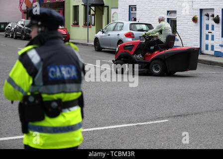 Ein Mann fährt eine Fahrt auf Rasenmäher hinter einem Gardasee checkpoint im Dorf Doonbeg, Co Clare, während des Besuchs von US-Präsident Donald Trump. Stockfoto