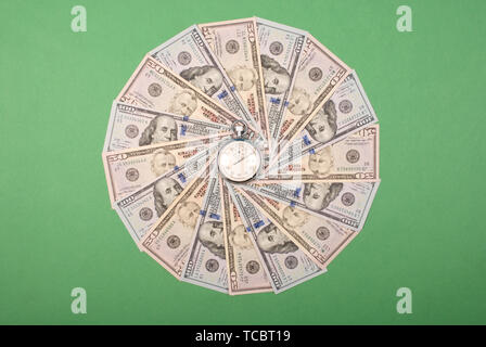Stoppuhr auf dem Mandala Kaleidoskop von Geld. Abstrakte Geld Hintergrund raster Muster wiederholen Mandala Kreis. Stockfoto