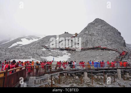 Yunnan, die chinesische Provinz Yunnan. 6. Juni, 2019. Touristen besuchen Sie den Jade Dragon Snow Mountain Scenic Area in Lijiang, im Südwesten der chinesischen Provinz Yunnan, 6. Juni 2019. Wang Zhen, ein Tourist aus Nanjing, der ostchinesischen Provinz Jiangsu, wurde der 50-millionste Besucher auf der Jade Dragon Snow Mountain Scenic Area am Donnerstag. Die glücklichen Touristen das Leben gegeben - Zeit freien Zugang zu den landschaftlich reizvollen Gegend. Credit: Qin Qing/Xinhua/Alamy leben Nachrichten Stockfoto