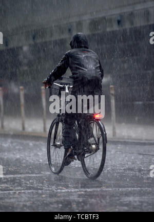 Berlin, Deutschland. 06 Juni, 2019. Ein Radfahrer ist auf der Straße nass mit Regen. Credit: Lisa Ducret/dpa/Alamy leben Nachrichten Stockfoto