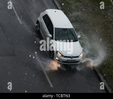 Berlin, Deutschland. 06 Juni, 2019. Ein Auto fährt durch eine Pfütze von Regen in der Turmstraße. Credit: Paul Zinken/dpa/Alamy leben Nachrichten Stockfoto