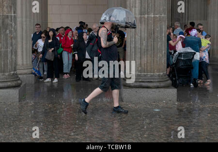 Berlin, Deutschland. 06 Juni, 2019. Touristen suchen Schutz vor dem Regen am Pariser Platz. Credit: Paul Zinken/dpa/Alamy leben Nachrichten Stockfoto