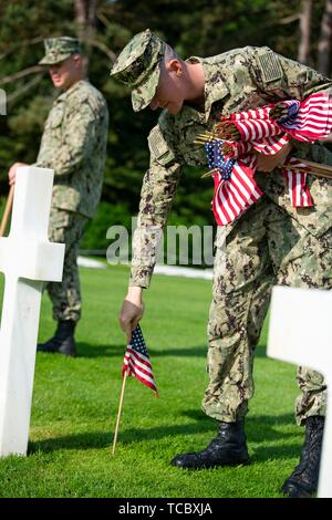 Colleville Sur Mer, Frankreich. 05 Juni, 2019. Us-Marine Seeleute Ort amerikanische Flaggen auf die Gräber auf dem Friedhof und Denkmal der Normandie Juni 5, 2019 in Colleville-sur-Mer, Frankreich. Tausende haben liefen auf die Normandie das 75-jährige Jubiläum der Operation Overlord, die Invasion der Alliierten im Zweiten Weltkrieg allgemein als D-Day bekannt zu gedenken. Credit: Planetpix/Alamy leben Nachrichten Stockfoto