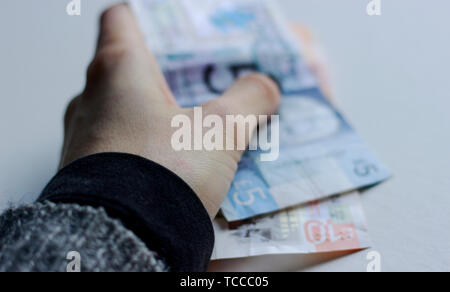 Bank von Schottland Noten, Noten des Pfund Sterling, Mai 2019, UK. Frau mit Pfund Papier schottische Banknoten über isolierte Hintergrund. Stockfoto