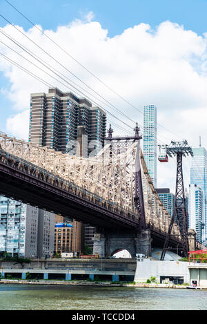 Low Angle View der Ed Koch die Queensboro Bridge, und eine Straßenbahnlinie, auch bekannt als die 59th Street Bridge, von Roosevelt Island gesehen mit dem Manha Stockfoto