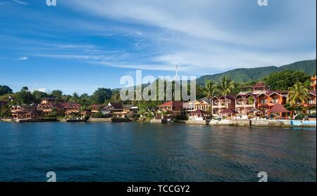 Häuser und Hotels am Lake Toba bei Tuk Tuk Halbinsel, Insel Samosir, Sumatra, Indonesien.