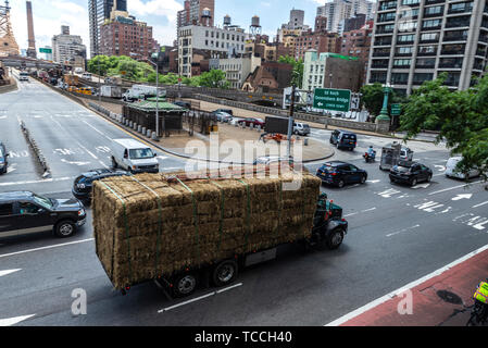 New York City, USA - 31. Juli 2018: Lkw mit Strohballen auf einer Straße vor der Queensboro Bridge in New York City, USA zirkulierenden geladen Stockfoto