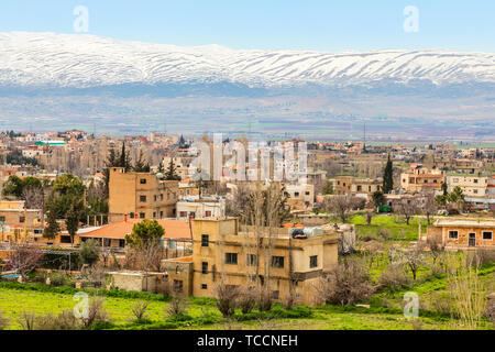 Libanesische Häuser in der Beqaa Tal mit Schnee die Berge im Hintergrund, Baalbek, Libanon Stockfoto
