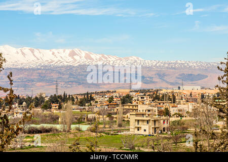 Libanesische Häuser in der Beqaa Tal mit Schnee die Berge im Hintergrund, Baalbek, Libanon Stockfoto