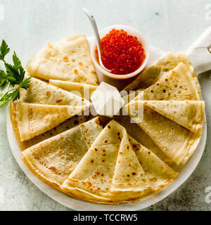 Die traditionellen russischen Pfannkuchen mit roter Kaviar und Butter auf dem weißen Tisch Stockfoto