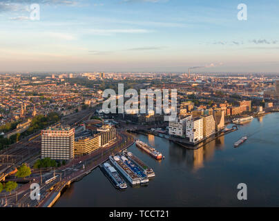 Luftaufnahme des zentralen Teils von Amsterdam, neuer Bezirk von IJdock und Kanalkreuzfahrtschiffe, Niederlande Stockfoto