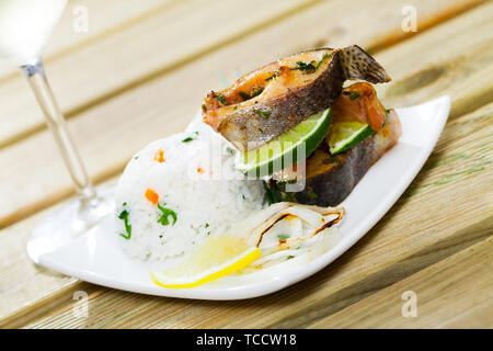 Ofen gebackene Forellen Steaks serviert mit Reis und Zitrone Stockfoto