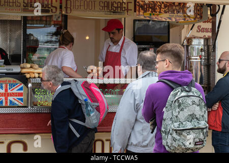 Die Menschen in der Warteschlange für Essen zu einem fast food van auf einem Festival Stockfoto