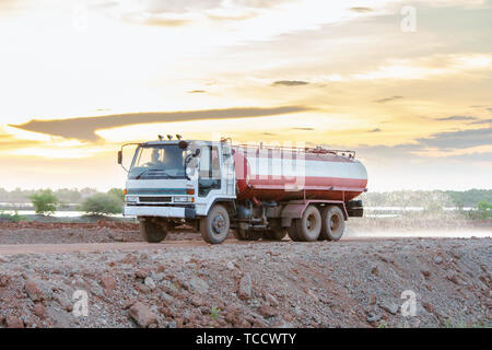 Wasser Lkw sprays Wasser für eine neue Straße Baustelle. Stockfoto