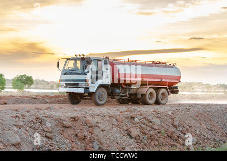 Wasser Lkw sprays Wasser für eine neue Straße Baustelle. Stockfoto