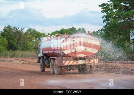 Wasser Lkw sprays Wasser für eine neue Straße Baustelle. Stockfoto