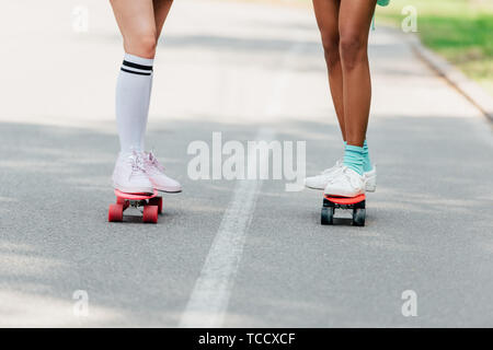 Teilweise mit Blick auf die zwei Mädchen skateboarding auf penny Boards auf der Straße Stockfoto