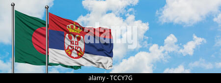 Bangladesch und Serbien Flagge im Wind gegen Weiße bewölkt blauer Himmel zusammen. Diplomatie Konzept, internationale Beziehungen. Stockfoto