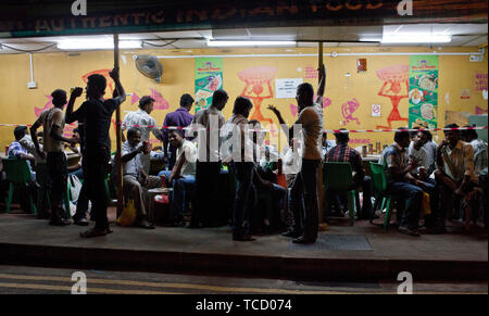 Wanderarbeiter in Little India an einem Sonntag Abend entspannen. Singapur Stockfoto