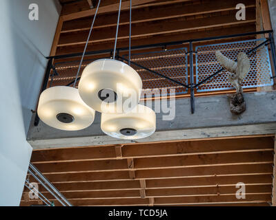 Hängende Lampe mit festen Eule in der Nähe der zweiten Geschichte der offenen Strahl Gebäude Stockfoto