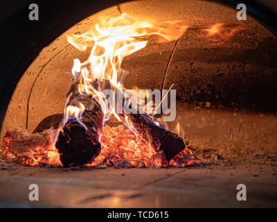 Flammen, Protokolle, Asche und Glut im Inneren Holzofen Pizza Ofen Stockfoto