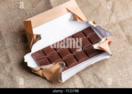 Schokoriegel in Papier wrapper liegt auf der Leinwand. Stockfoto