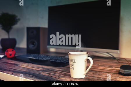 Große Tasse heißen dampfenden Kaffee auf einen Schreibtisch in einem Büro vor einem Desktop Computer, Monitor und Tastatur in der Nähe zu sehen. Stockfoto