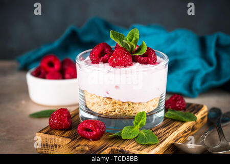 Keine gebackene Käsekuchen mit Himbeeren im Glas. Stockfoto