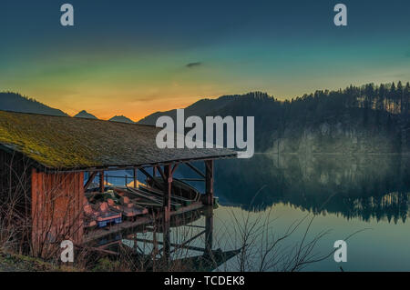 Haus am See mit einem kleinen Pier vor die Berge. Stockfoto