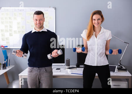 Nahaufnahme der männlichen und weiblichen Unternehmer Trainieren in Office mit Hanteln Stockfoto