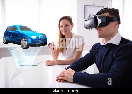 Mann, der VR-Headset an PKW-Modell mit weiblichen Agent, Remote Stockfoto