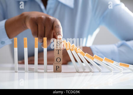 Frau stoppen Zigarette fallen auf dem Schreibtisch mit Holz unterbauen Stockfoto