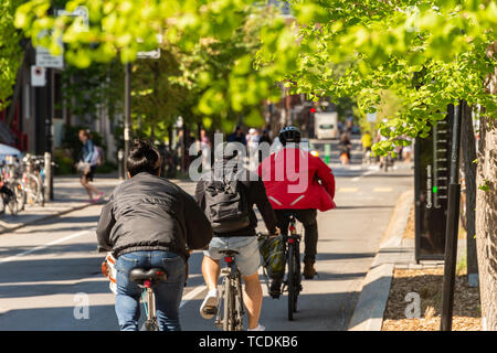 Montreal, Kanada - 6. Juni 2019: Menschen sind Fahrrad auf einem Radweg, der auf Laurier Straße in der Hochebene Nachbarschaft. Stockfoto