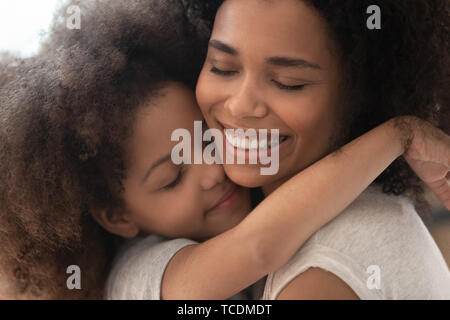 Gerne zärtlich afrikanischen Familie Mutter und Kind Tochter umarmen Stockfoto