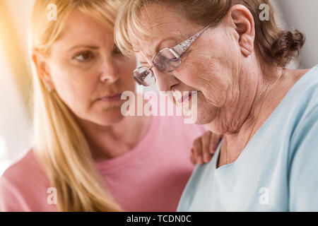 Junge Frau tröstet traurige Senior Erwachsenfrau. Stockfoto