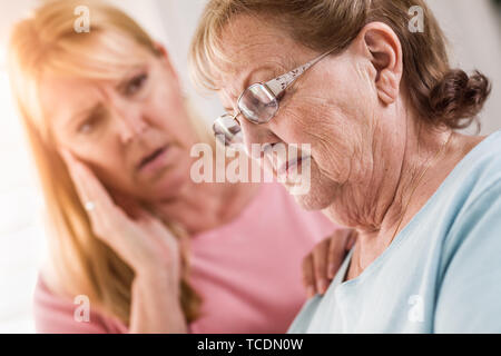 Junge Frau tröstet traurige Senior Erwachsenfrau. Stockfoto