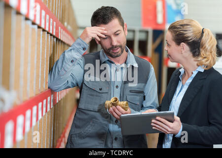 Portrait von Mann und Frau mit Tablet im Lager Stockfoto