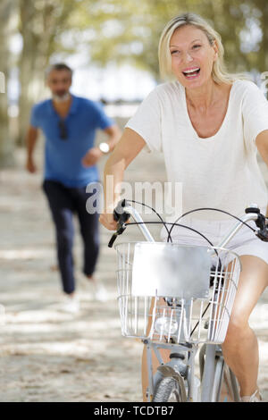 Ältere Frau reiten City Bike in der Stadt Stockfoto