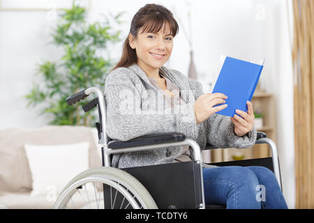 Behinderte Frau im Rollstuhl ein Buch lesen Stockfoto