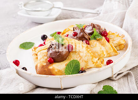 Pfannkuchen mit Beeren und Schokolade mit Minze Blatt eingerichtet. Leckeres Frühstück. Stockfoto