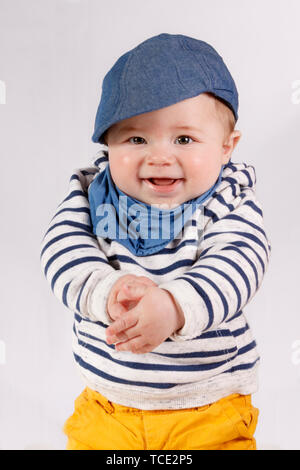 Nahaufnahme Porträt einer lächelnden Jungen tragen ein Lätzchen und Hut Stockfoto